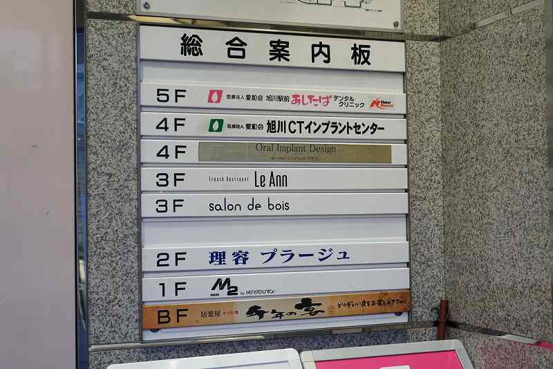 明治屋ビルの総合案内版が壁に貼られている