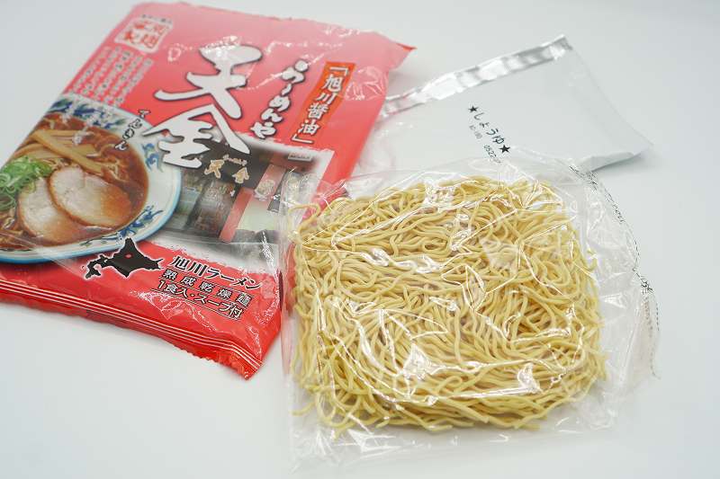 天金の袋ラーメンの中身、熟成乾燥麺とスープ（1人分）がテーブルに置かれている