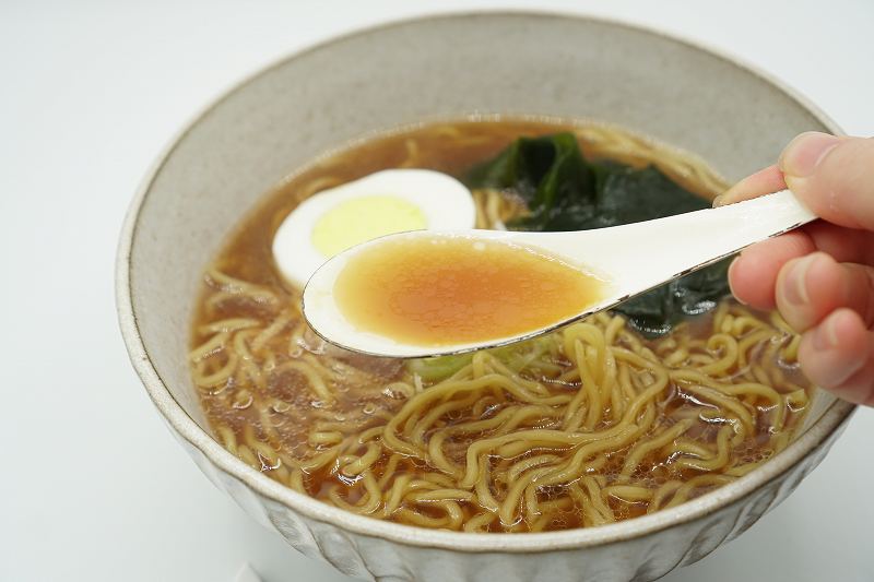 天金の袋ラーメンのスープをれんげですくっている様子