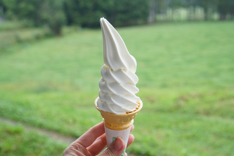 伊勢ファーム カウ&カーフの「ソフトクリーム レギュラー(税込350円)」を手に持っている様子