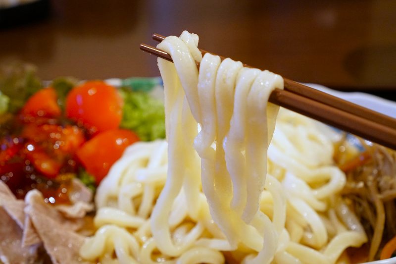 手作りうどん杉の「きんぴらの冷やしうどん」の麺を箸で持ち上げている様子