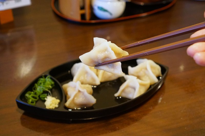 すぎ餃子を箸で持ち上げている様子