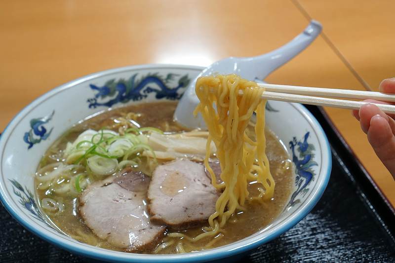 らーめんや天金の正油ラーメンの麺を箸で持ち上げている様子