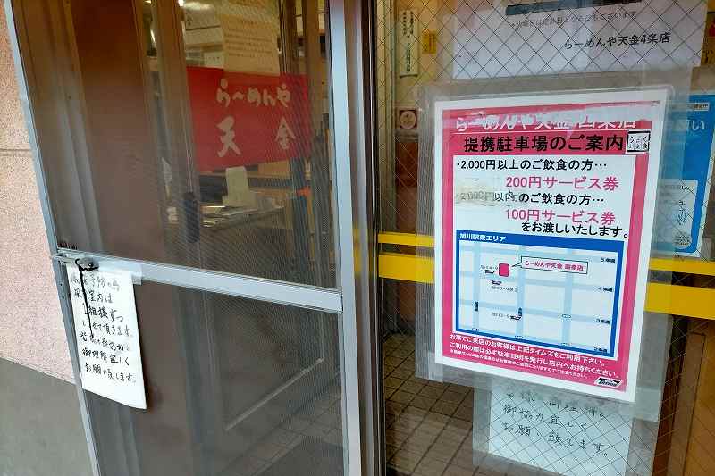 提携駐車場の案内がガラスドアに貼られている