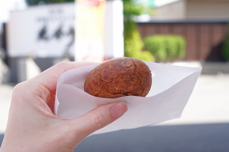 「揚げたてあんドーナッツ(税込130円)」を手に持っている様子