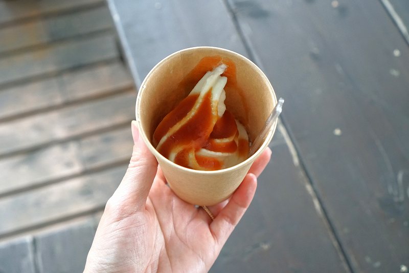 谷口農場の「トマトソースミニソフト カップ(税込320円)」を手に持っている様子