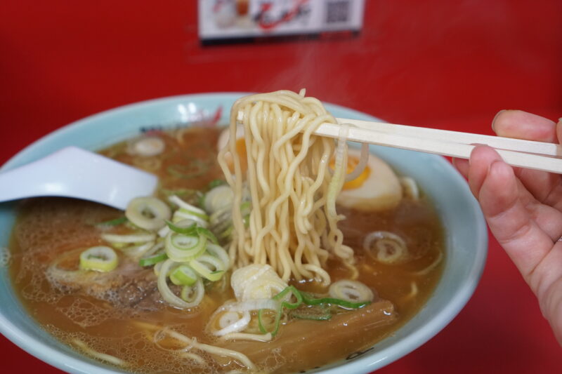 梅光軒 旭川本店の醤油ラーメンの麺を箸で持ち上げている様子