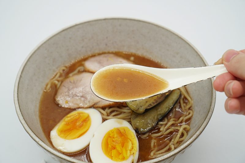 旭川ラーメン 蜂屋のおみやげ生ラーメンのスープをれんげですくっている様子