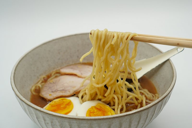 旭川ラーメン 蜂屋のおみやげ生ラーメンの麺を箸で持ち上げている様子