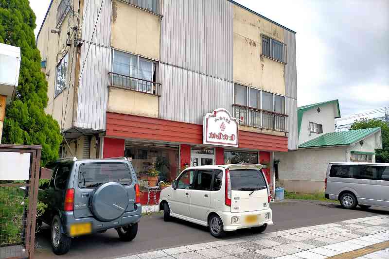赤と白の看板をかかげた「ケーキハウス カトルカール」の店舗外観