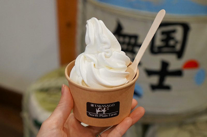 高砂酒造の「酒粕ソフトクリーム(税込370円)」を手に持っている様子