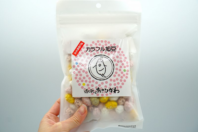 「【道の駅あさひかわ限定品】カラフル旭豆 150g（税込378円）」を手に持っている様子