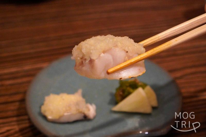 旭川「鮨みなと」の「甘鯛 の焼き物」を箸で持ち上げている様子